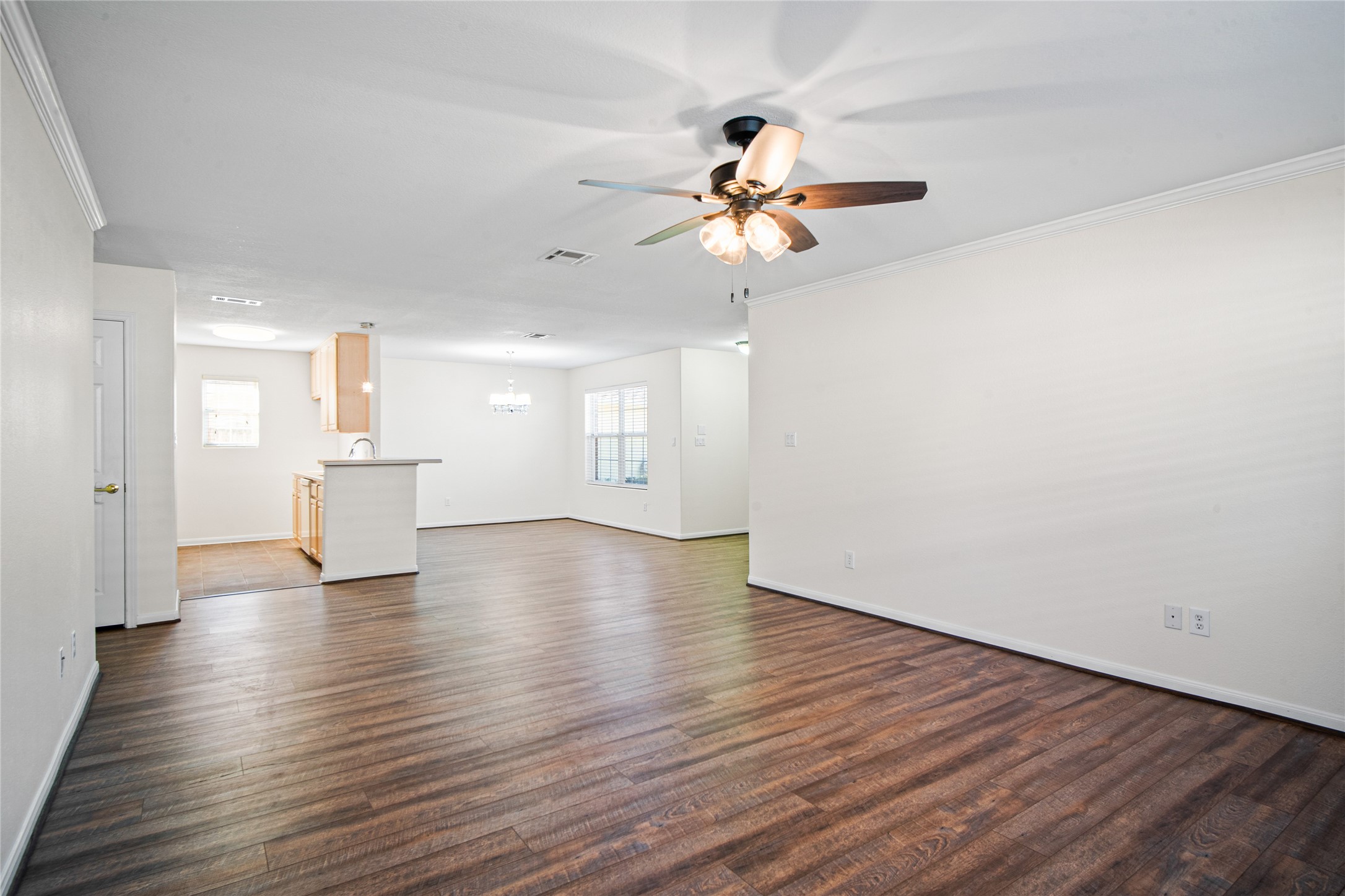 2224 Shady Tree Lane Conroe, TX 77301 - Photo 10 of 20 a view of an empty room with wooden floor and a ceiling fan