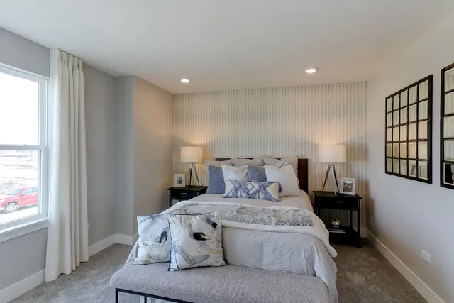 a large bed sitting in a room next to a window