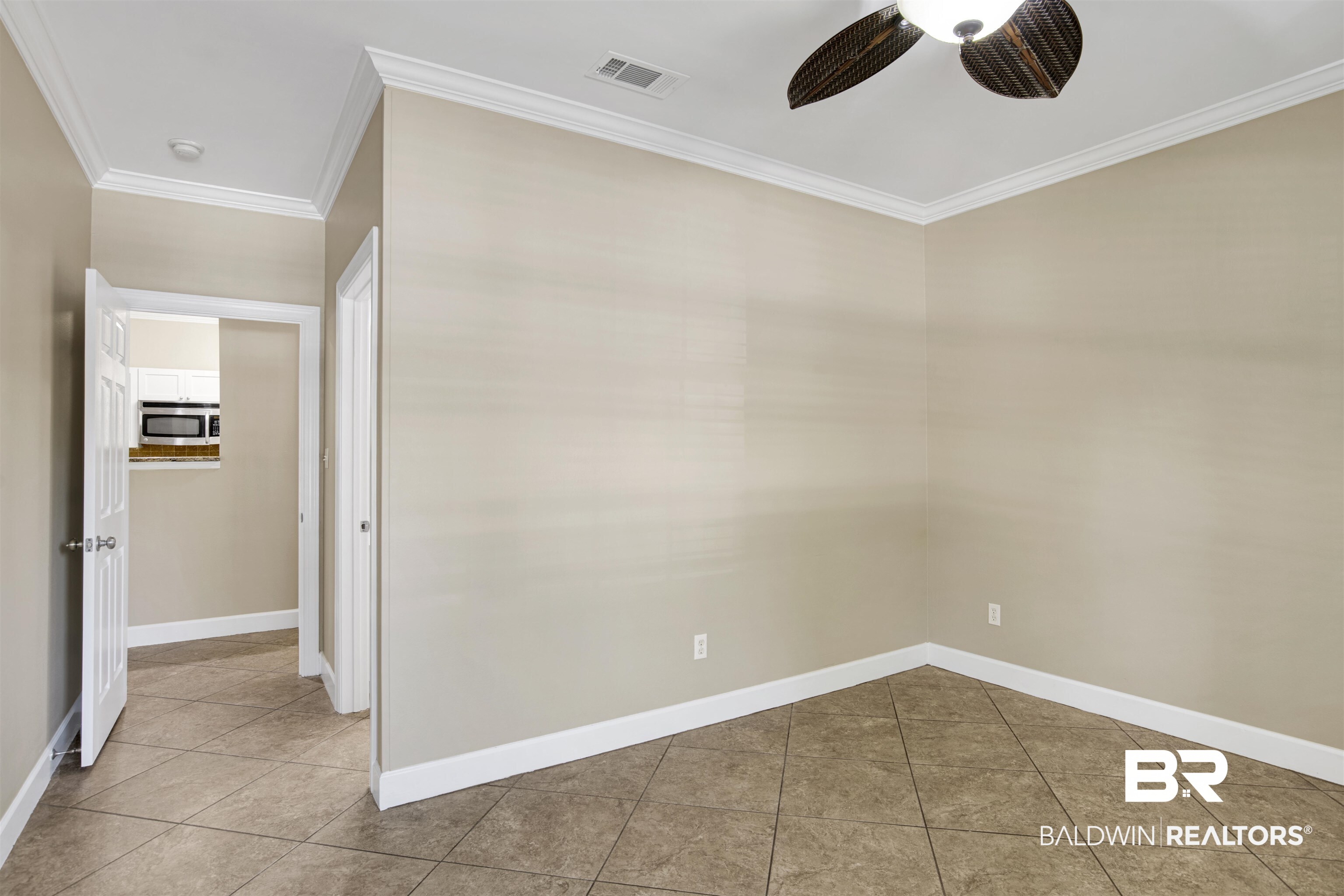 450 Park Avenue, Unit 202 Foley, AL 36535 - Photo 7 of 18 Spare room with ornamental molding, light tile patterned floors, and ceiling fan