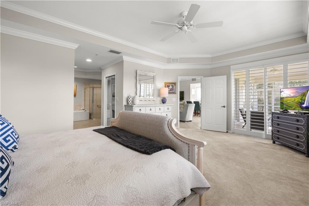 1635 Winding Oaks Way, Unit 101 Naples, FL 34109 - Photo 15 of 37 a bedroom with a large bed and ceiling fan