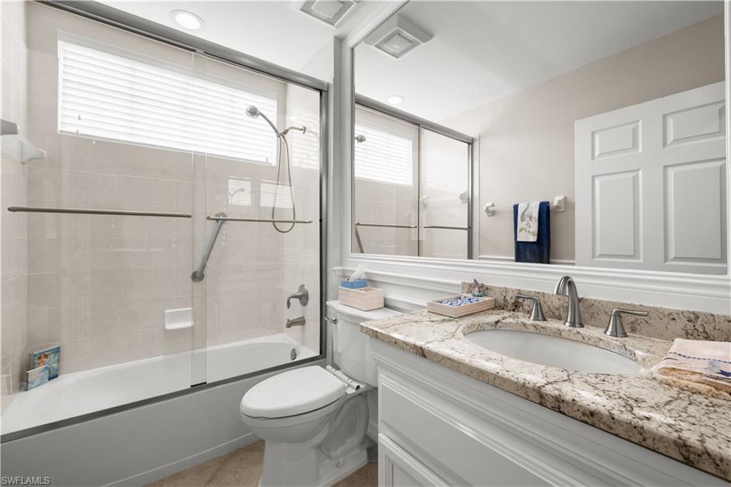 1635 Winding Oaks Way, Unit 101 Naples, FL 34109 - Photo 20 of 37 a bathroom with a granite countertop sink toilet and shower
