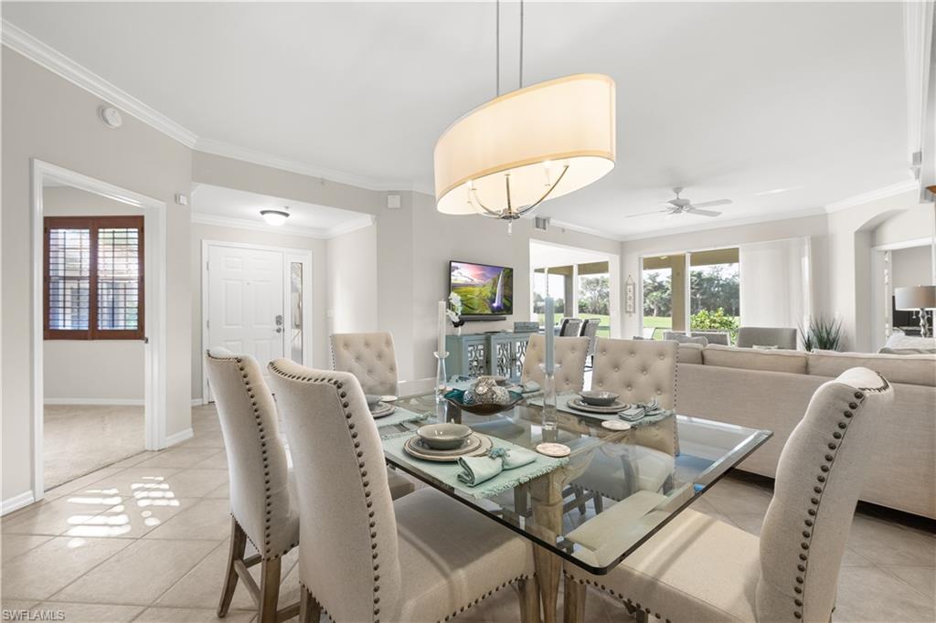 1635 Winding Oaks Way, Unit 101 Naples, FL 34109 - Photo 5 of 37 a view of a dining room with furniture and a chandelier