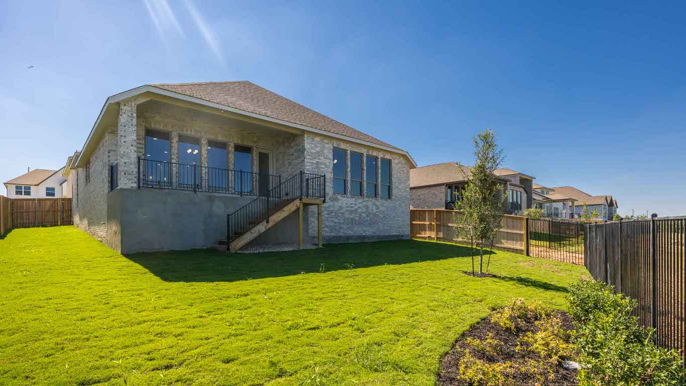255 Star Rush Trail Georgetown, TX 78633 - Photo 12 of 16 Back of property featuring a fenced backyard, stairway, and brick siding
