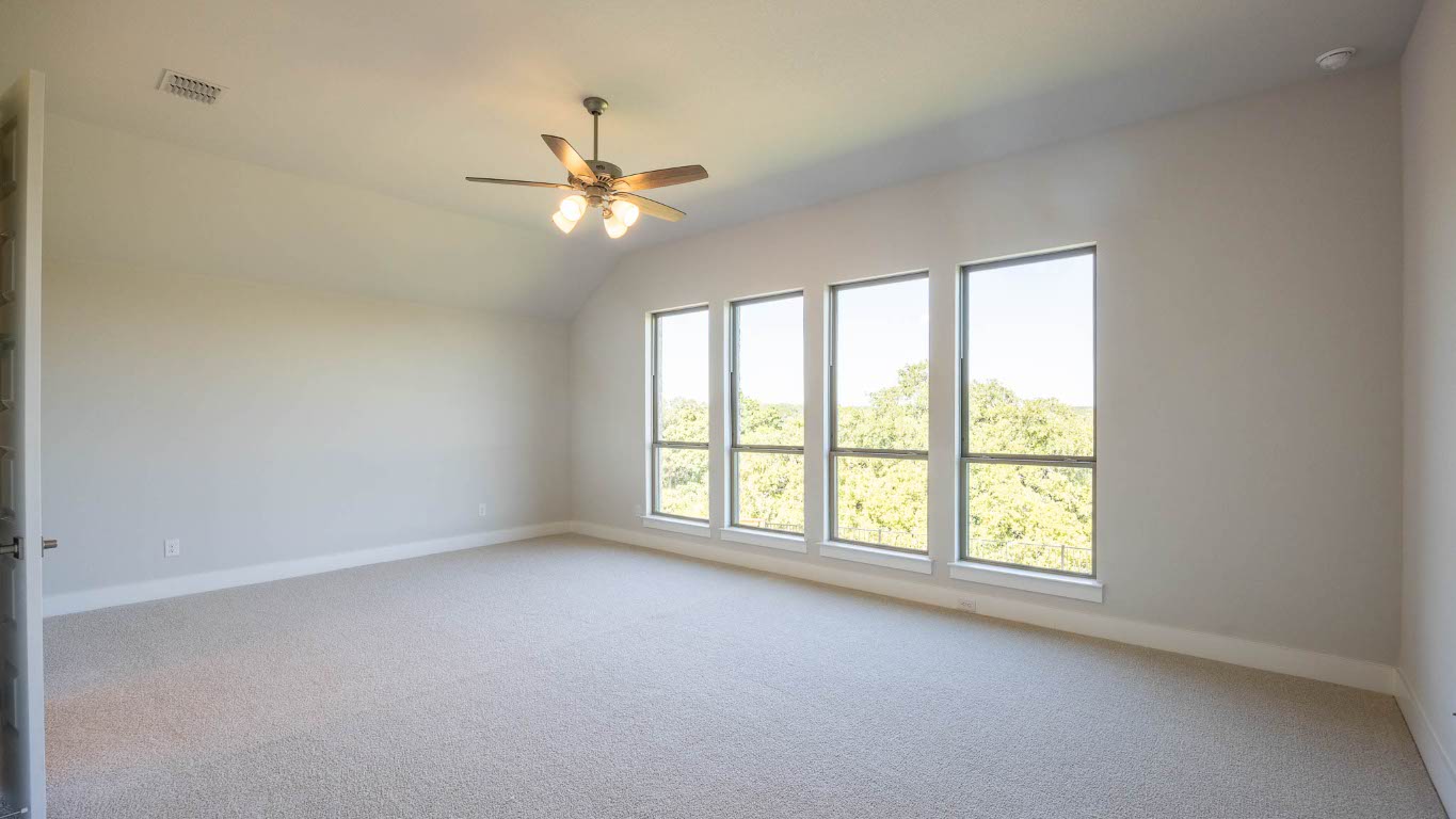 255 Star Rush Trail Georgetown, TX 78633 - Photo 9 of 16 Empty room featuring light colored carpet, ceiling fan, and lofted ceiling