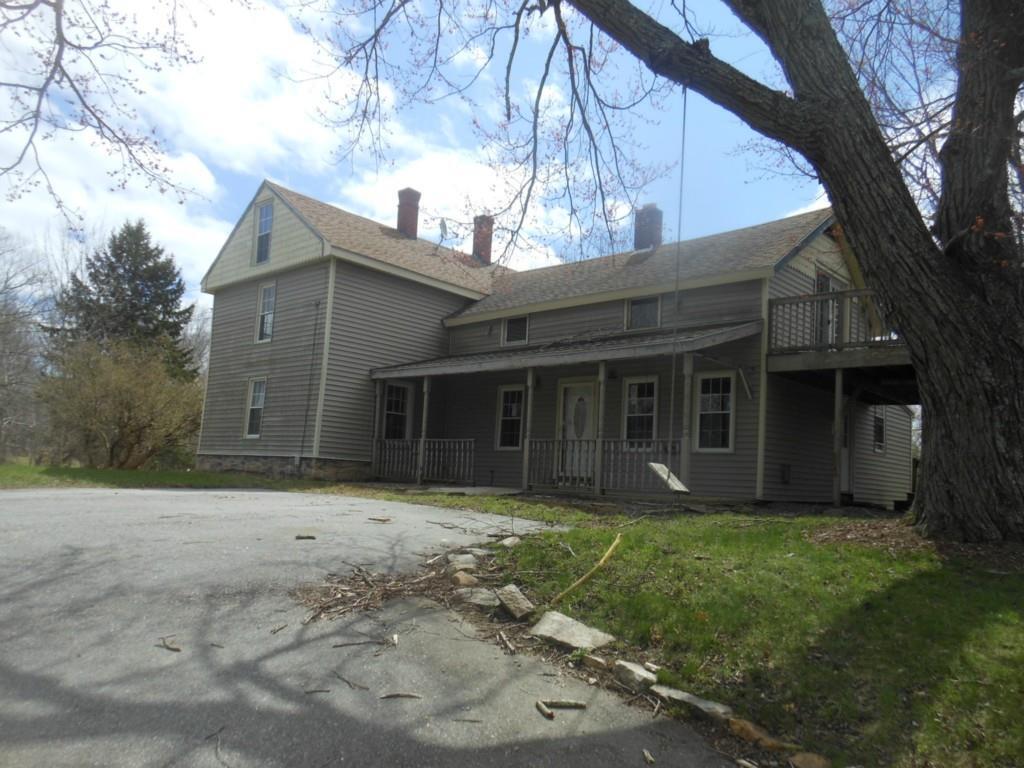 a front view of a house with a garden and trees