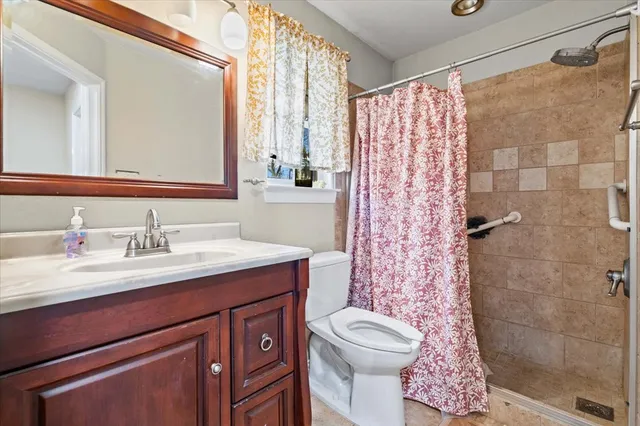 a bathroom with a granite countertop sink toilet and shower