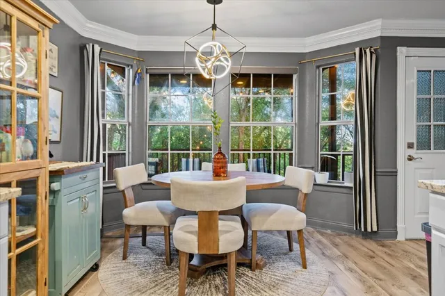 a dining room with furniture a chandelier and wooden floor