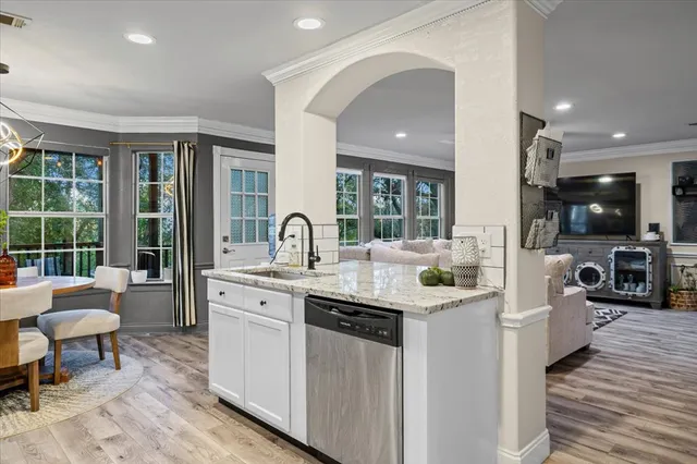 a kitchen with stainless steel appliances kitchen island granite countertop a sink and cabinets