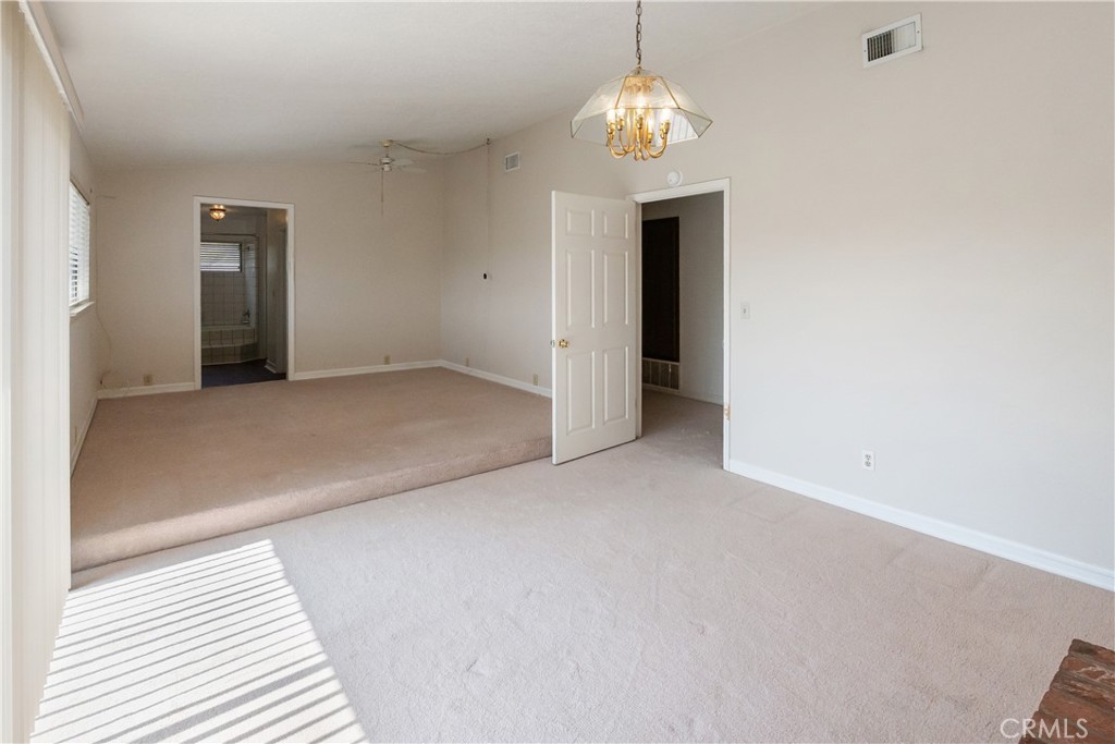 17656 Mockingbird Hill Circle Riverside, CA 92504 - Photo 18 of 49 an empty room with a chandelier