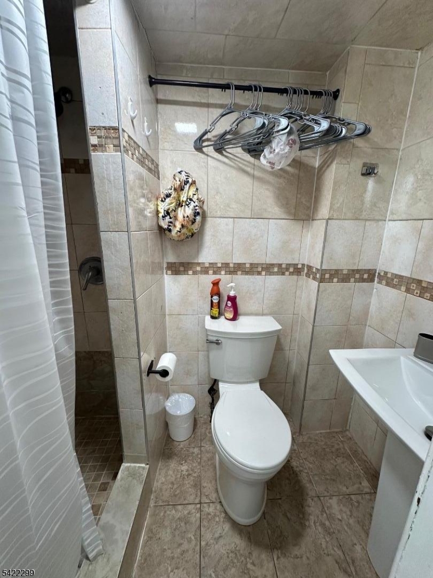 113 Pequannock Street Dover, NJ 07801 - Photo 15 of 17 a white toilet sitting next to a bathroom sink and a shower