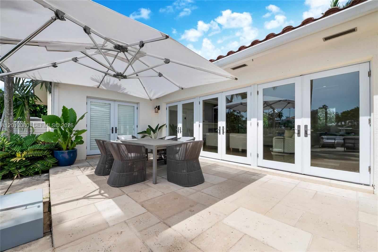 13035 Nevada Street Coral Gables, FL 33156 - Photo 14 of 21 a view of a patio with table and chairs potted plants with large tree