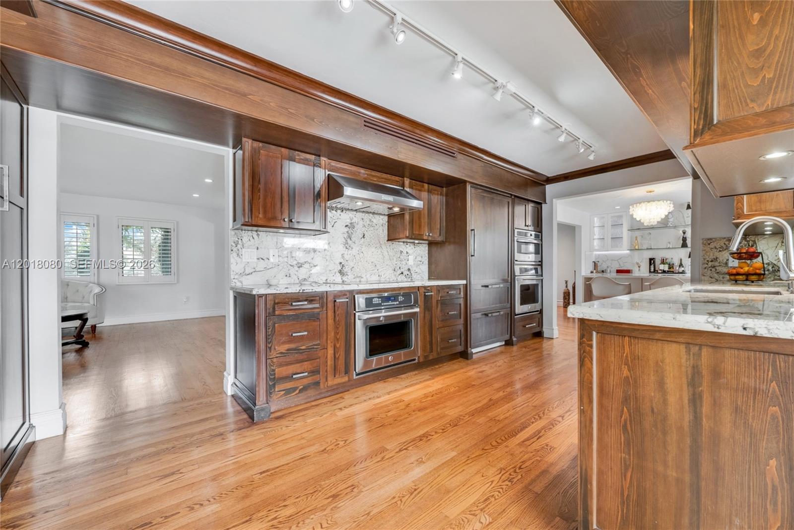 13035 Nevada Street Coral Gables, FL 33156 - Photo 8 of 21 a large kitchen with stainless steel appliances granite countertop a stove and cabinets with wooden floor