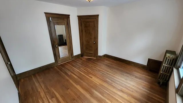 a view of a room with wooden floor and a window