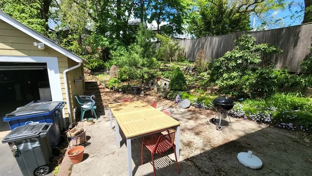 a backyard of a house with table and chairs