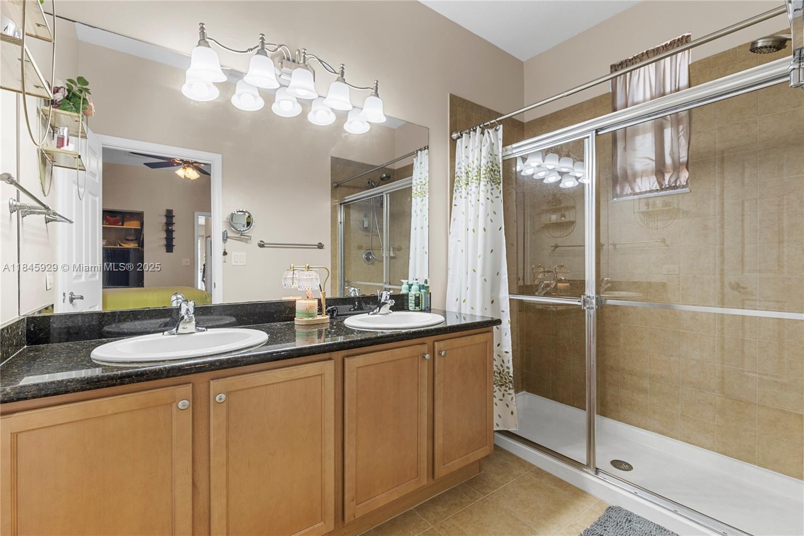 1112 Southwest 146th Terrace Pembroke Pines, FL 33027 - Photo 28 of 42 a bathroom with a granite countertop sink a mirror and shower