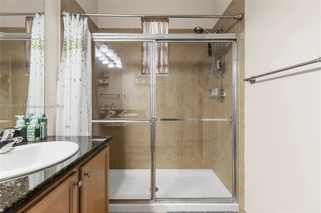 a bathroom with a shower sink and mirror