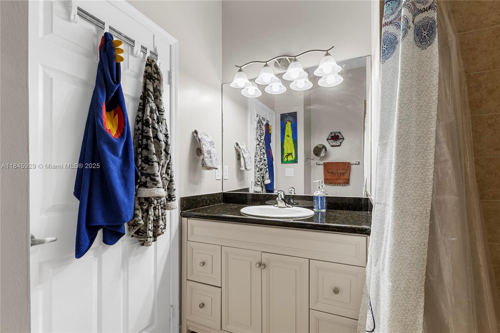 1112 Southwest 146th Terrace Pembroke Pines, FL 33027 - Photo 32 of 42 a bathroom with a sink vanity and a mirror