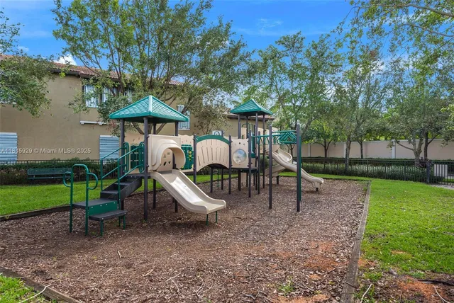 a view of outdoor space with playground and green space