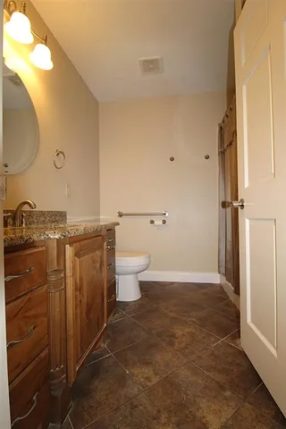 a bathroom with a granite countertop sink toilet and shower