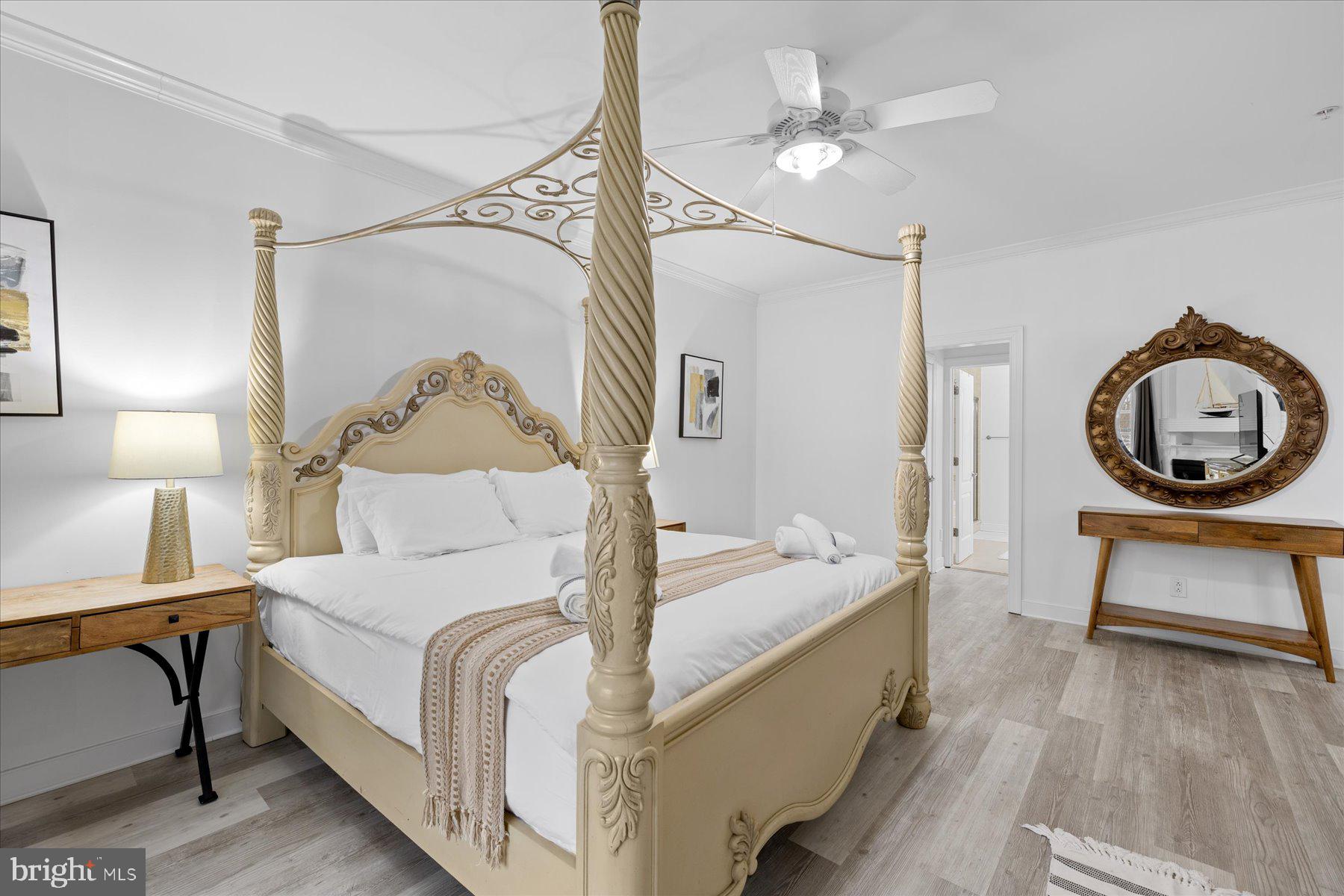 9823 Golf Course Road, Unit 10 Ocean City, MD 21842 - Photo 12 of 40 a bedroom with a bed and a chandelier