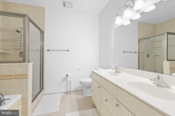 a bathroom with a double vanity sink mirror and toilet