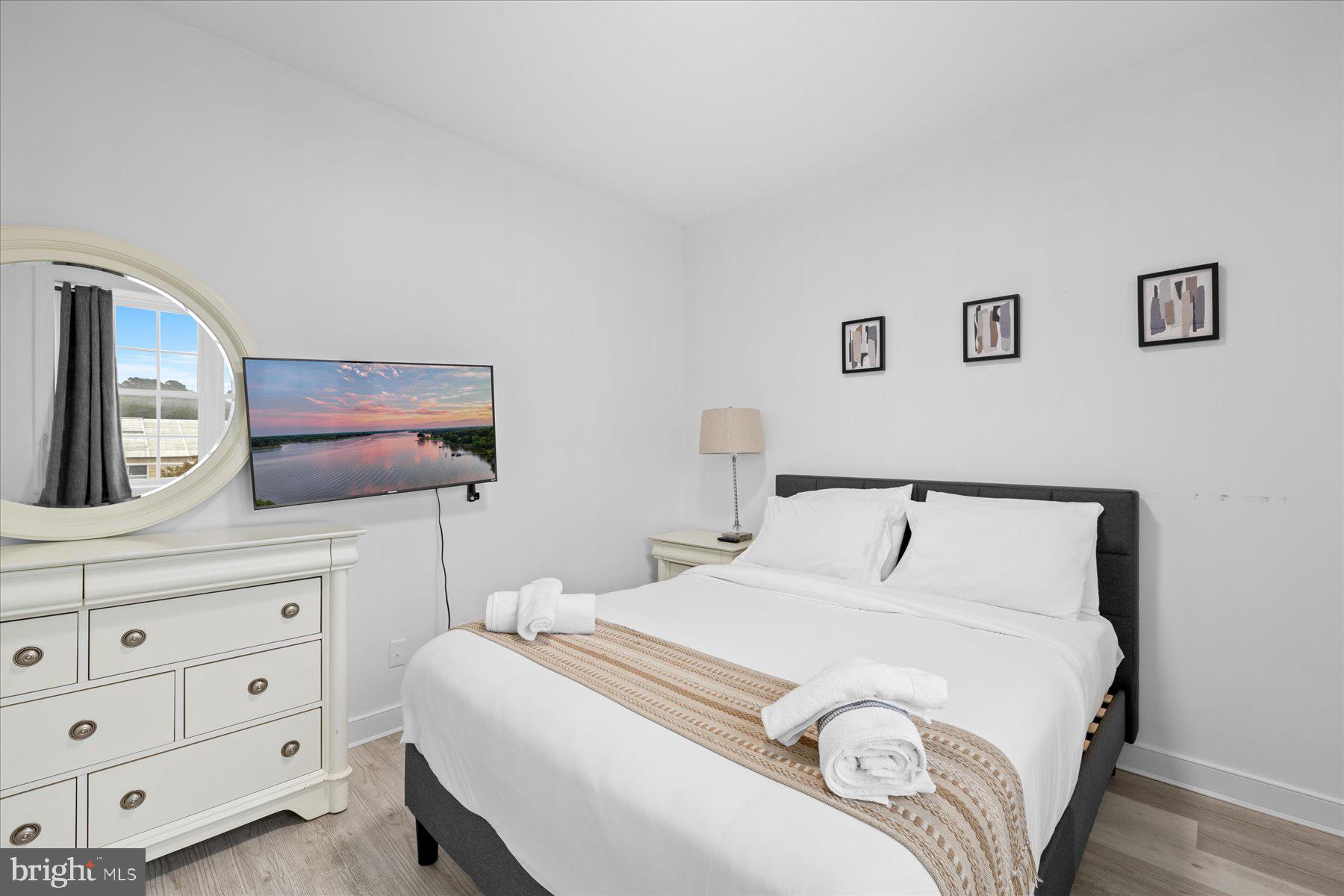 9823 Golf Course Road, Unit 10 Ocean City, MD 21842 - Photo 19 of 40 a bedroom with a bed and a dresser