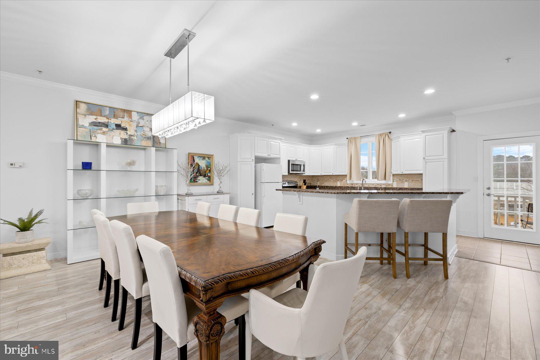 9823 Golf Course Road, Unit 10 Ocean City, MD 21842 - Photo 24 of 40 a view of a dining room and livingroom with furniture wooden floor a chandelier