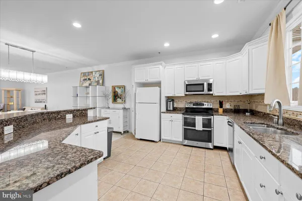 a kitchen with stainless steel appliances granite countertop a stove oven and a refrigerator