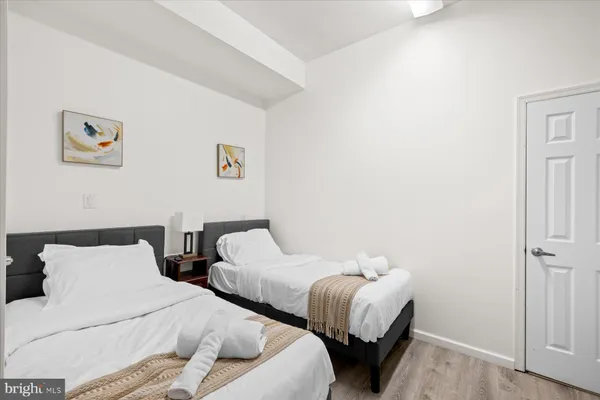 a bedroom with two beds and a lamp