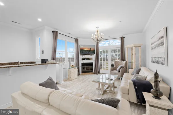 a living room with furniture kitchen view and a large window