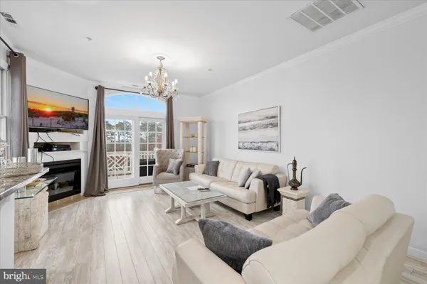 a living room with furniture large window and wooden floor