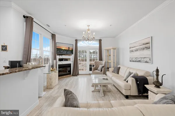 a living room with furniture a chandelier and a large window