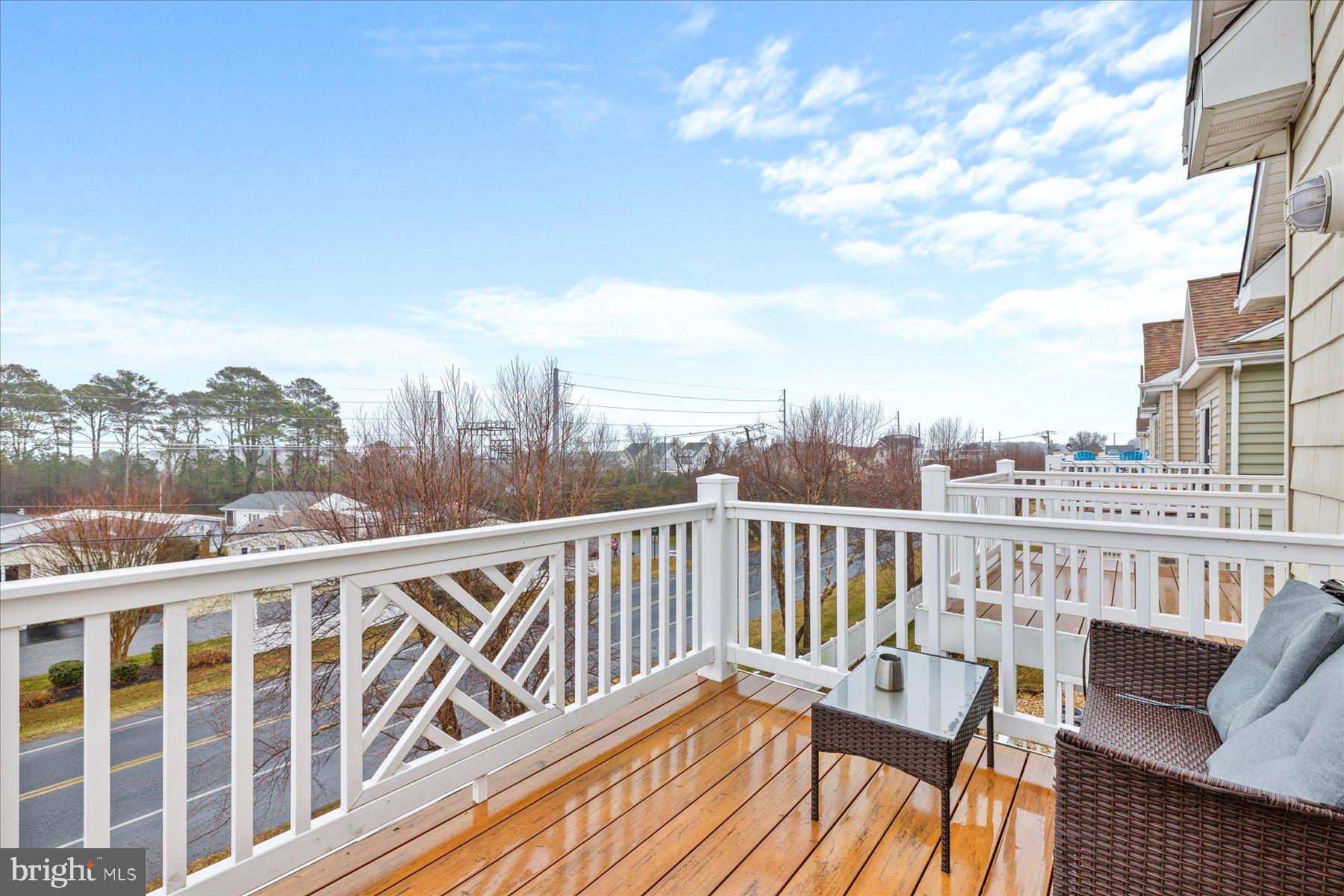 9823 Golf Course Road, Unit 10 Ocean City, MD 21842 - Photo 37 of 40 a view of a balcony with wooden chairs