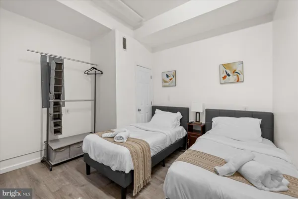 a bedroom with two beds and a wall painting