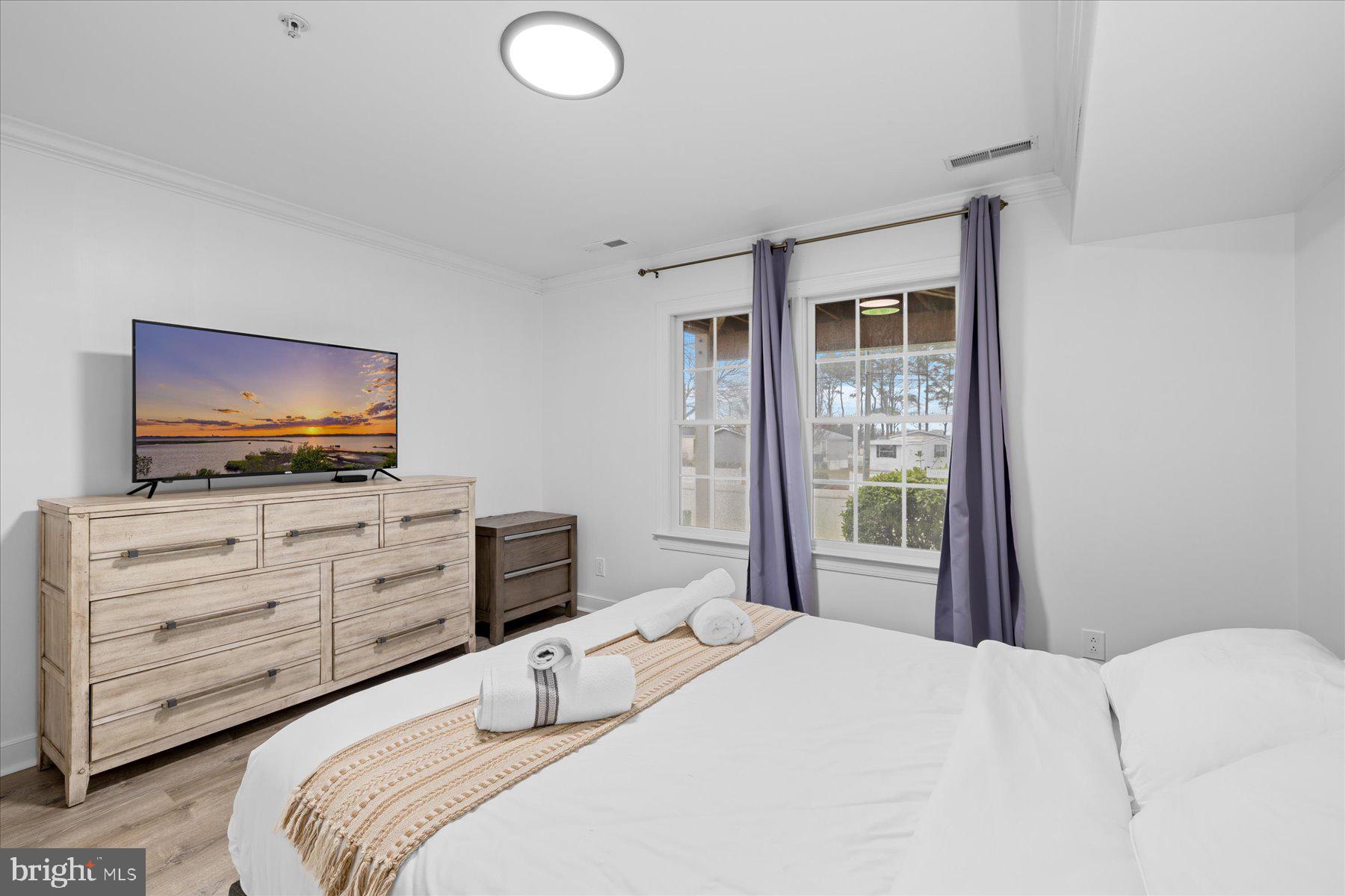 9823 Golf Course Road, Unit 10 Ocean City, MD 21842 - Photo 7 of 40 a bedroom with a bed and a flat screen tv