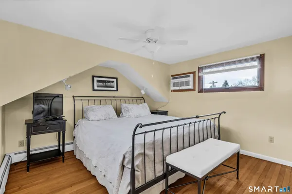 a bedroom with a bed and wooden floor