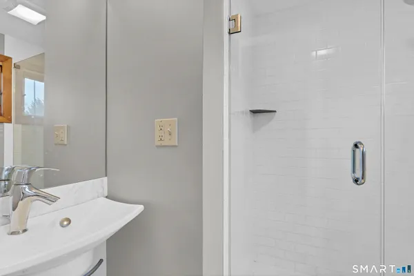 a bathroom with a sink a mirror and shower