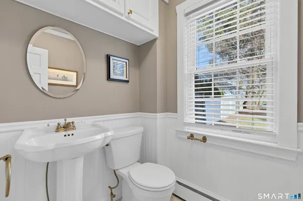 a bathroom with a sink a toilet and a mirror