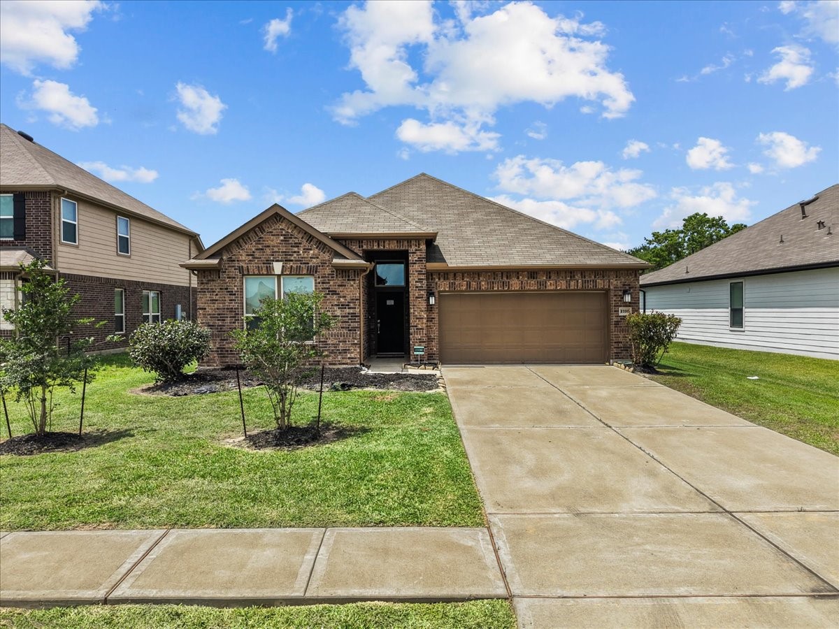 2320 Rosemary Street Rosenberg, TX 77469 - Photo 2 of 40 This photo shows a charming, single-story brick house with a two-car garage. It features a well-maintained front lawn and a neat driveway.