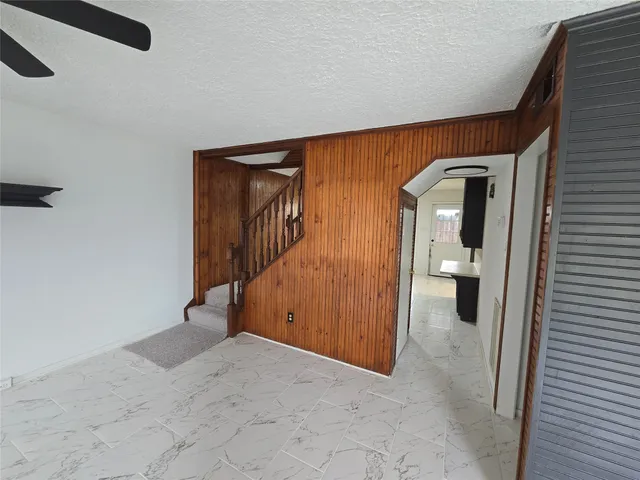a view of an empty room with furniture and a window