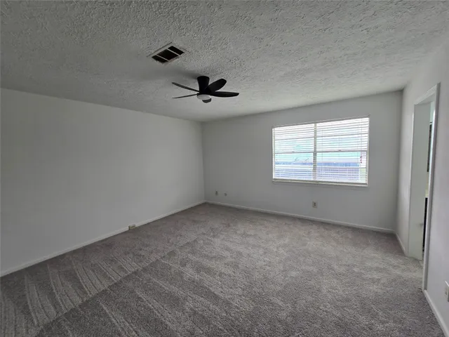 a view of an empty room with a ceiling fan
