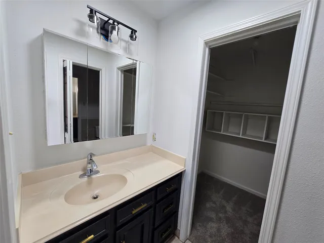 a bathroom with a sink toilet vanity and shower
