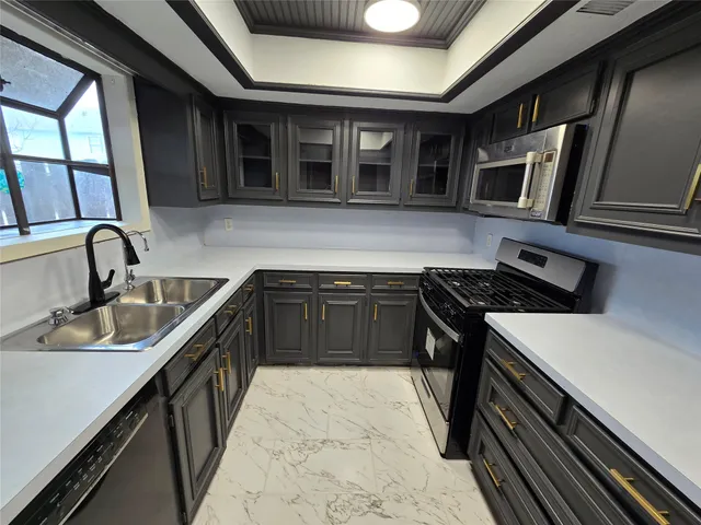 a kitchen with stainless steel appliances granite countertop a sink and a stove