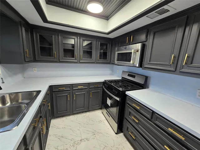 a kitchen with stainless steel appliances granite countertop a stove and a microwave