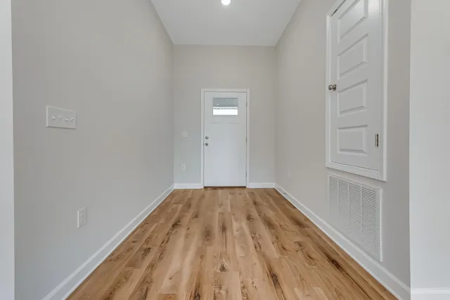 a view of a hallway with wooden floor