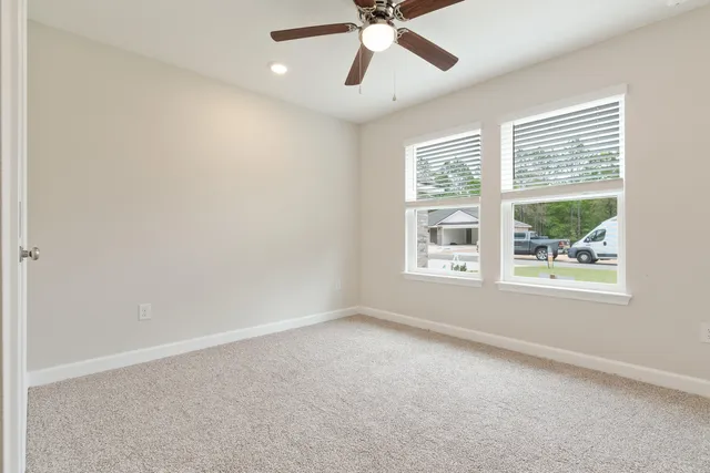 an empty room with a window and a fan