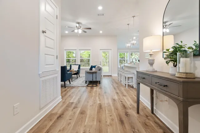 a living room with furniture a large window and wooden floor