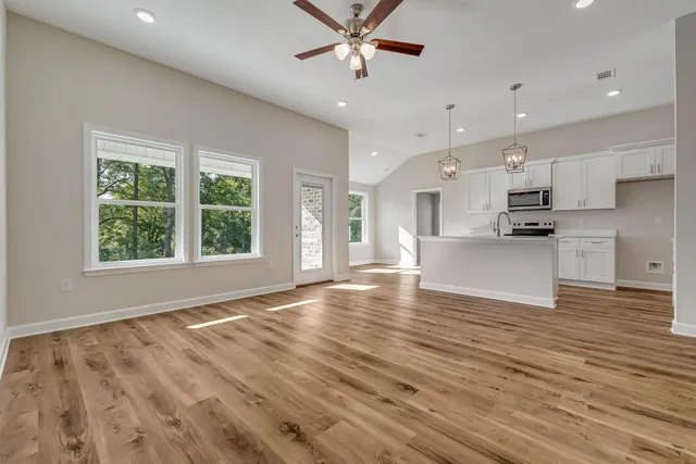 a view of an empty room with kitchen appliances and a window