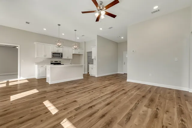 a view of a kitchen with a sink and dishwasher a refrigerator with wooden floor
