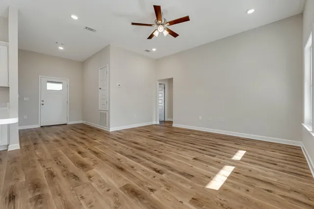 a view of empty room with wooden floor
